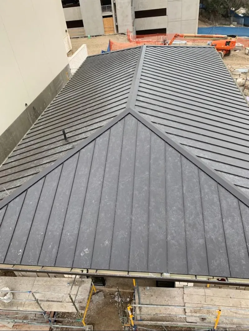 Commercial metal roof construction with crane equipment in North Manchester